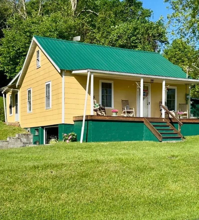 Cottage exterior repainted with fresh green metal roof coating