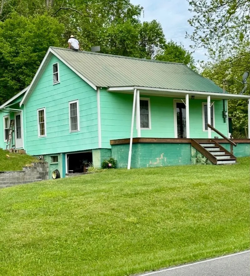 Before — Cottage exterior repainted with fresh green metal roof coating