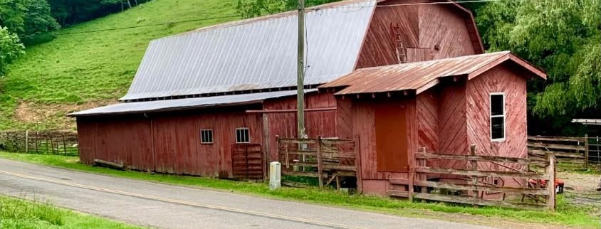 Before — Weathered red barn repainted with coated metal roof