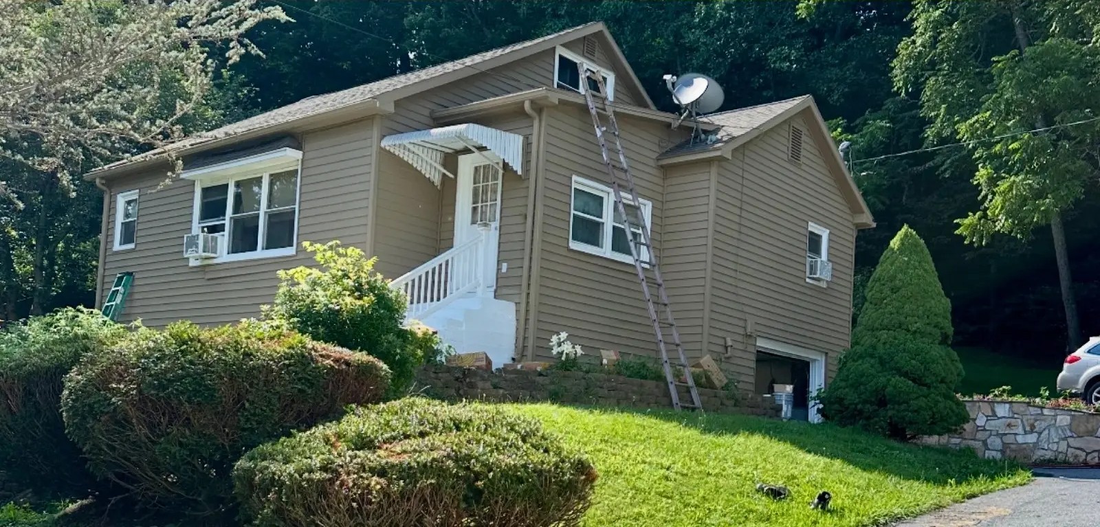 Residential home siding repainted from yellow to warm taupe
