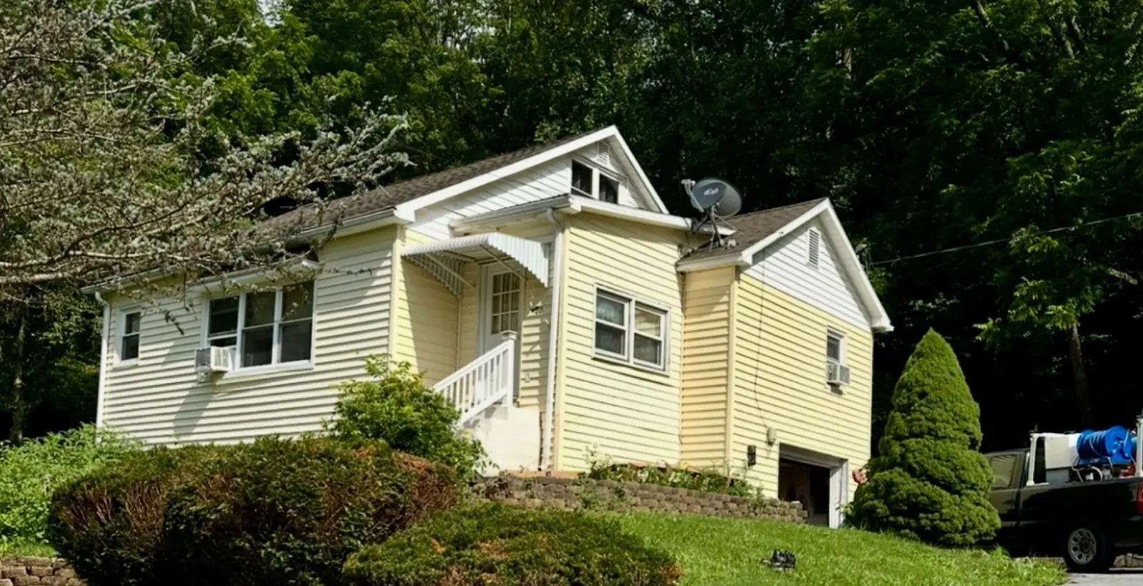 Before — Residential home siding repainted from yellow to warm taupe